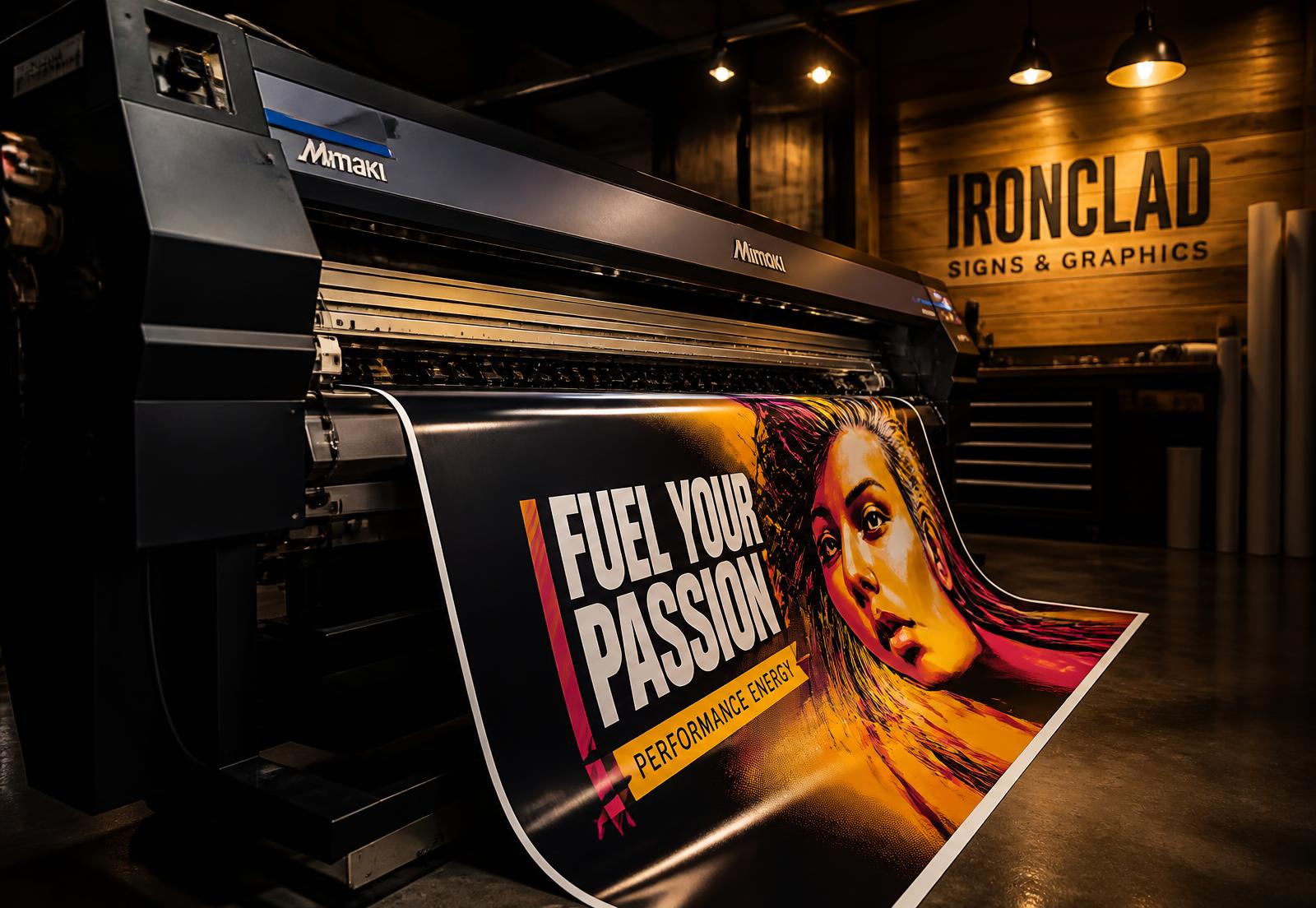 Wide-format printer producing a vinyl banner inside the Dandi Company sign shop